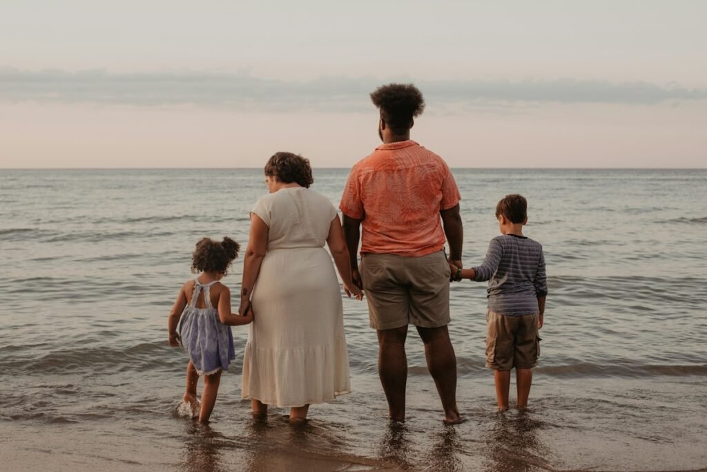 Familia de la mano mirando al mar
